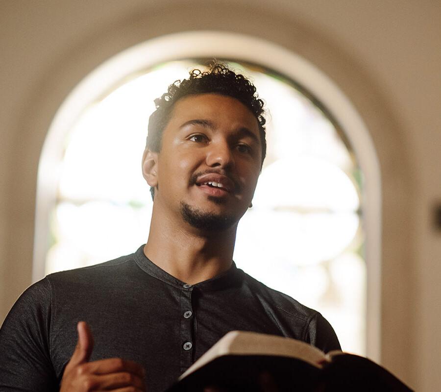 a PBA student holding a Bible while standing in the chapel